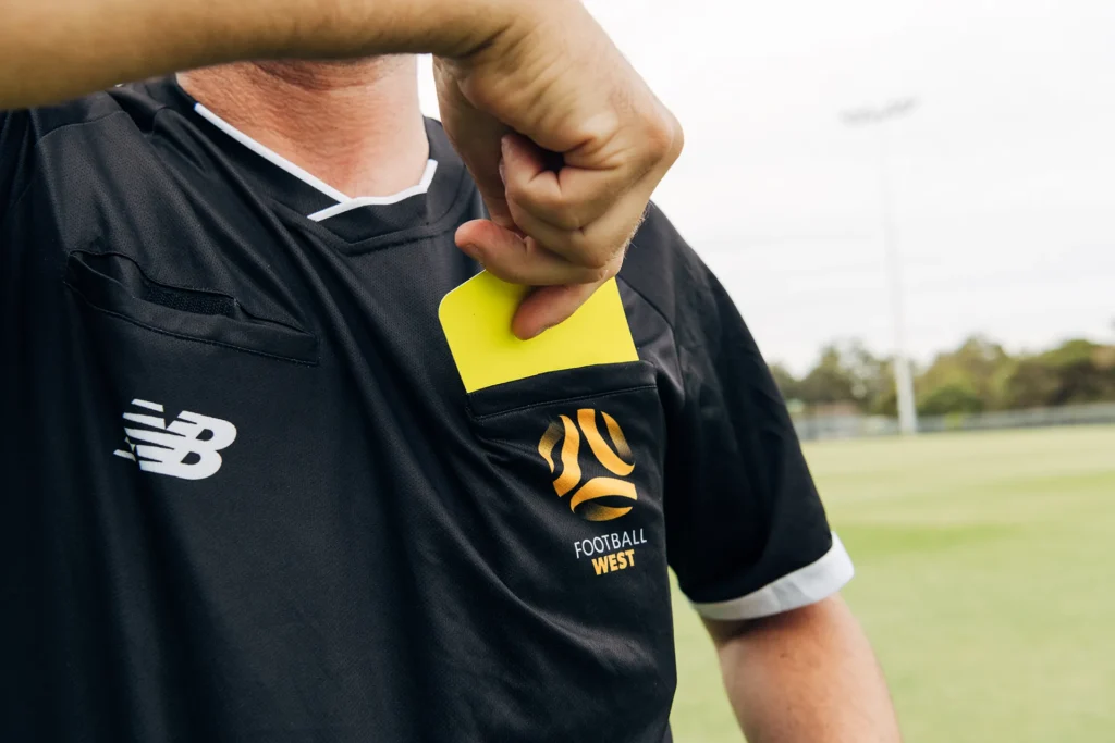 Closeup of umpire pulling out yellow card