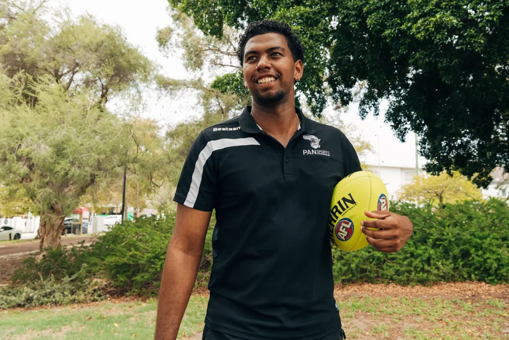 Man laughing holding football under his arm